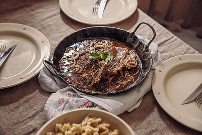 ein gedeckter Tisch mit Zwiebelfleisch, im Allgäu Traditionell aus gesiedetem Rindfleisch