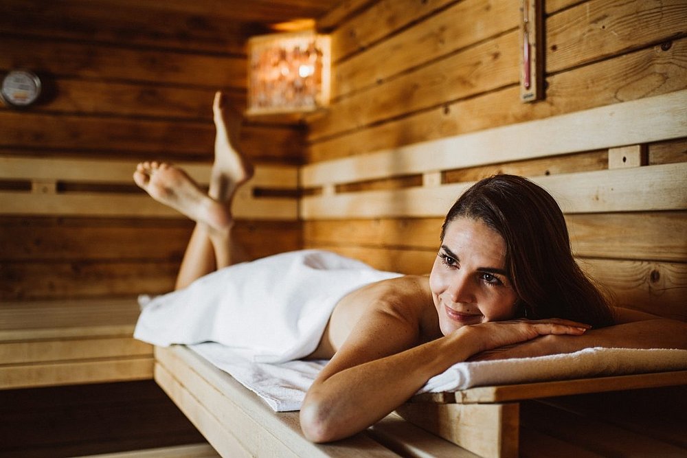 Frau liegt auf einer Liege in der Sauna im Gesundheitshotel König
