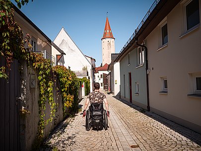 Moritz Brückner fährt im Rollstuhl durch eine Gasse in Mindelheim