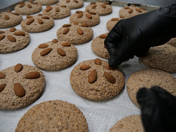 Mandeln werden auf ungebackene Lebkuchen gesetzt