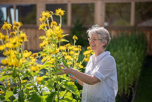 Frau im Garten mit gelben Blumen