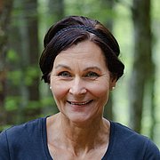 Christiane Haibel im Wald, ein Glas voll Fichtennadeln in der Hand