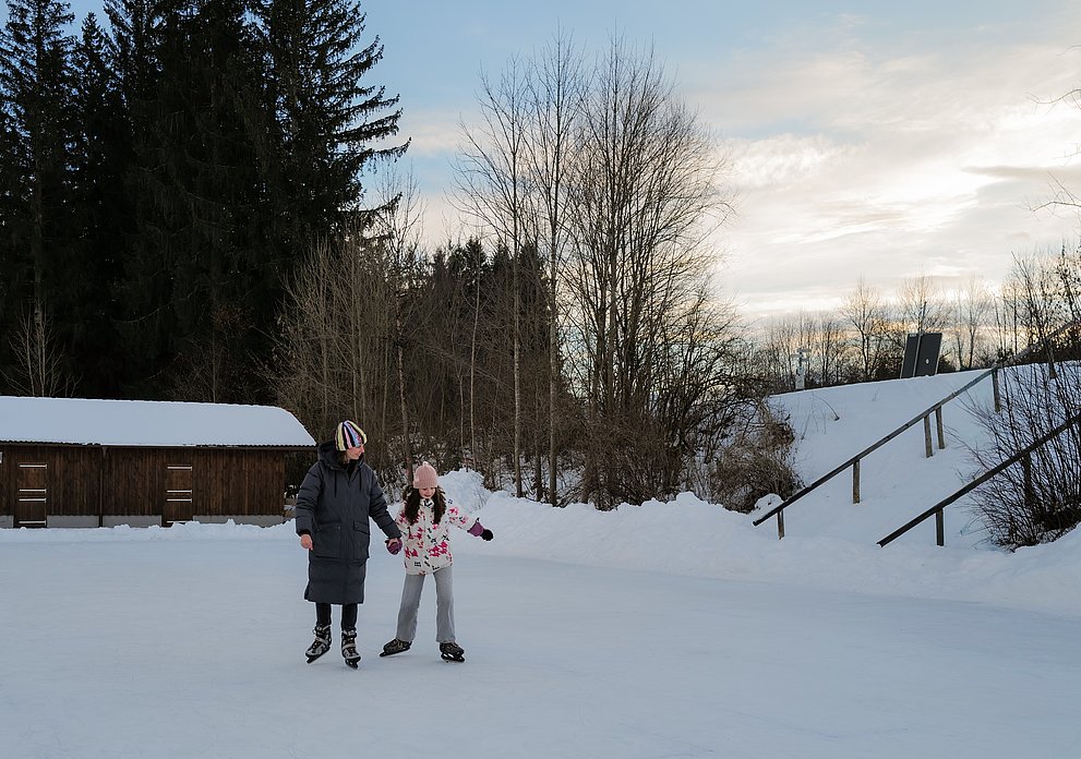 Mutter und Tochter auf dem Natureisplatz in Fischen