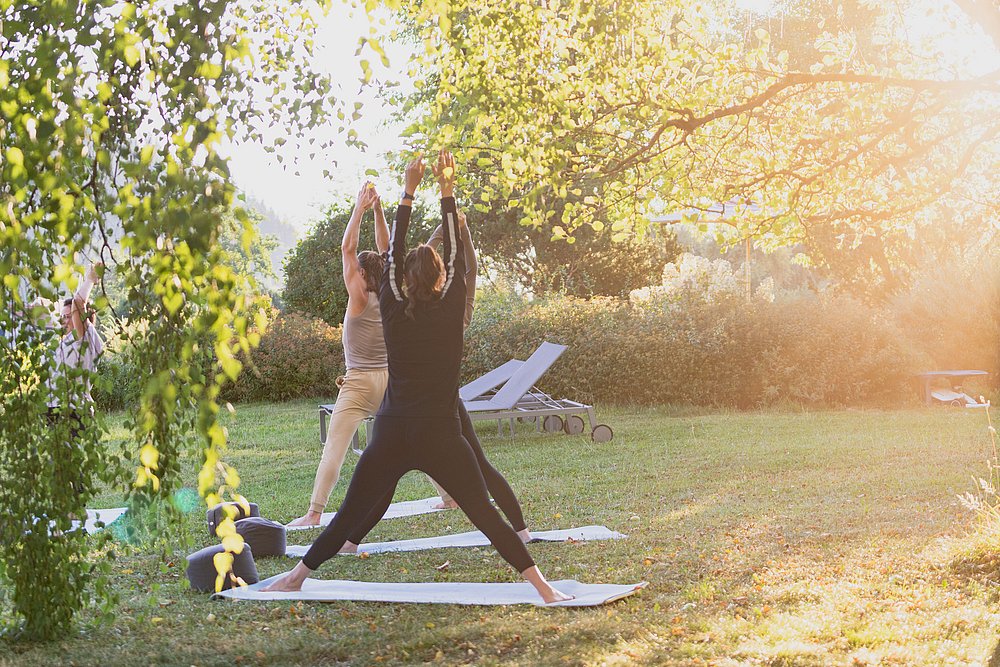 Gruppe macht Yoga im Garten des Gesundheitshotels König