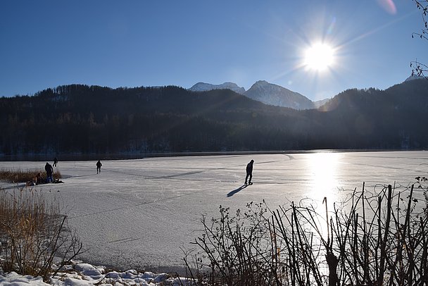 Menschen beim Eislaufen auf dem zugefrorenen Weissensee