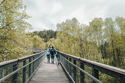 Familie auf dem Baumwipfelpfad im Walderlebniszentrum Füssen Familie auf dem Baumwipfelpfad im Walderlebniszentrum Füssen
