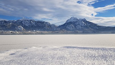 Gefrorener Forggensee und Berge