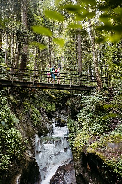 Wanderer auf Brücke in der Hausbachklamm bei Weiler im Allgäu