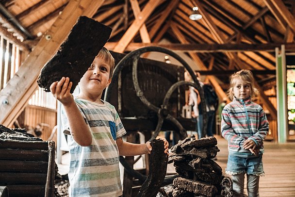 Kinder mit einem Stück Torf im Torfmuseum Bad Wurzach