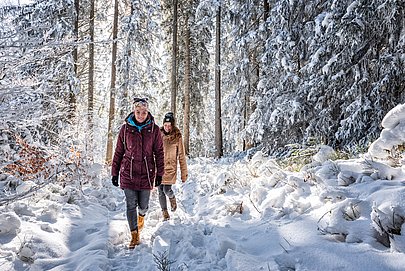 Zwei Frauen beim Winterwandern im Wald