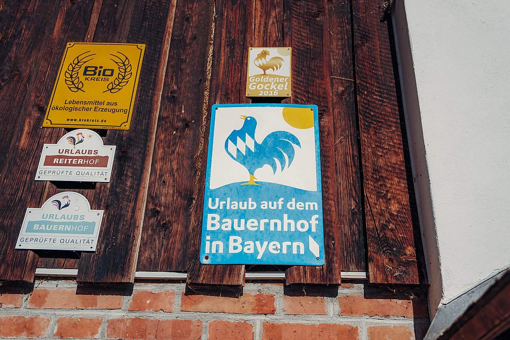 Schilder an der Hauswand des Ferienhofs Schöll
