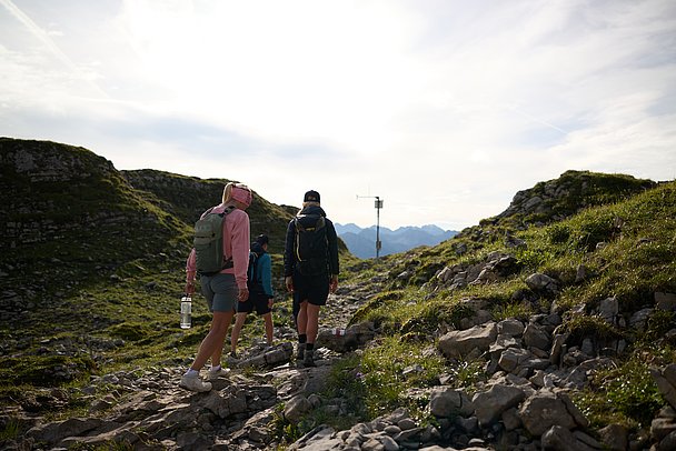 Wandergruppe in einer Landschaft aus Fels und Gras