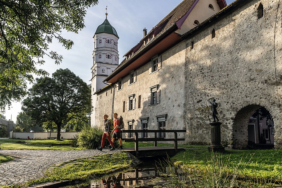 Wander-Pärchen vor der mittelalterlichen Wangener Stadtmauer mit Turm im Hintergrund