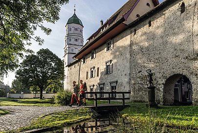 Wander-Pärchen vor der mittelalterlichen Wangener Stadtmauer mit Turm im Hintergrund