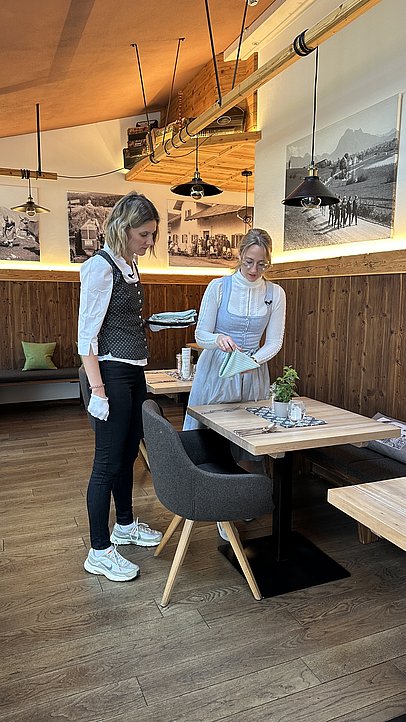 JobQuesterin Pia und Hoteldirektorin Johanna decken einen Tisch im Biohotels Eggensberger