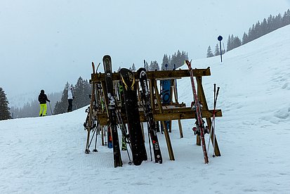 Ski- und Snowboard-Halter aus Holz an einer Skipiste