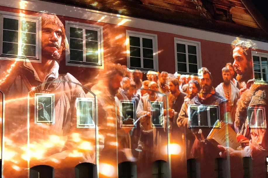 Eine Gruppe von Bauern ist auf eine Hauswand im Memmingen projiziert.