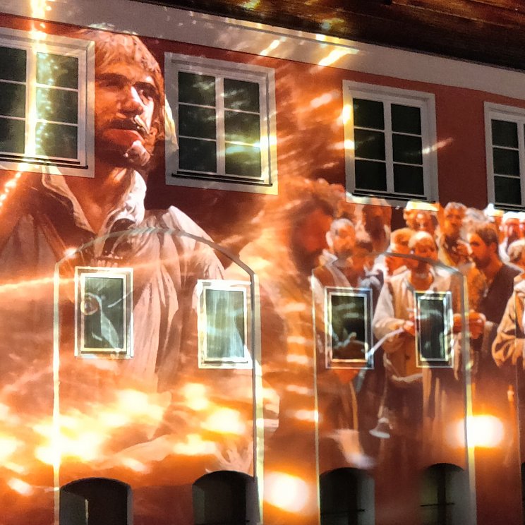 Eine Gruppe von Bauern ist auf eine Hauswand im Memmingen projiziert. Eine Gruppe von Bauern ist auf eine Hauswand im Memmingen projiziert.
