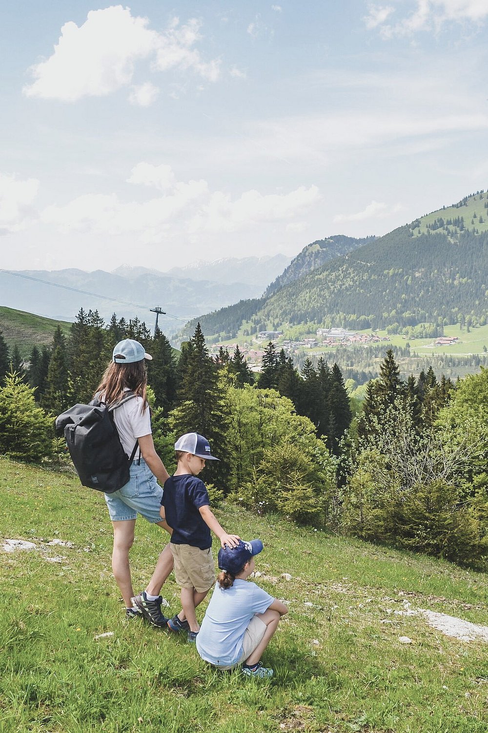 Mutter steht mit ihren Kindern auf einer Bergwiese, am Schmugglersteig in Oberjoch