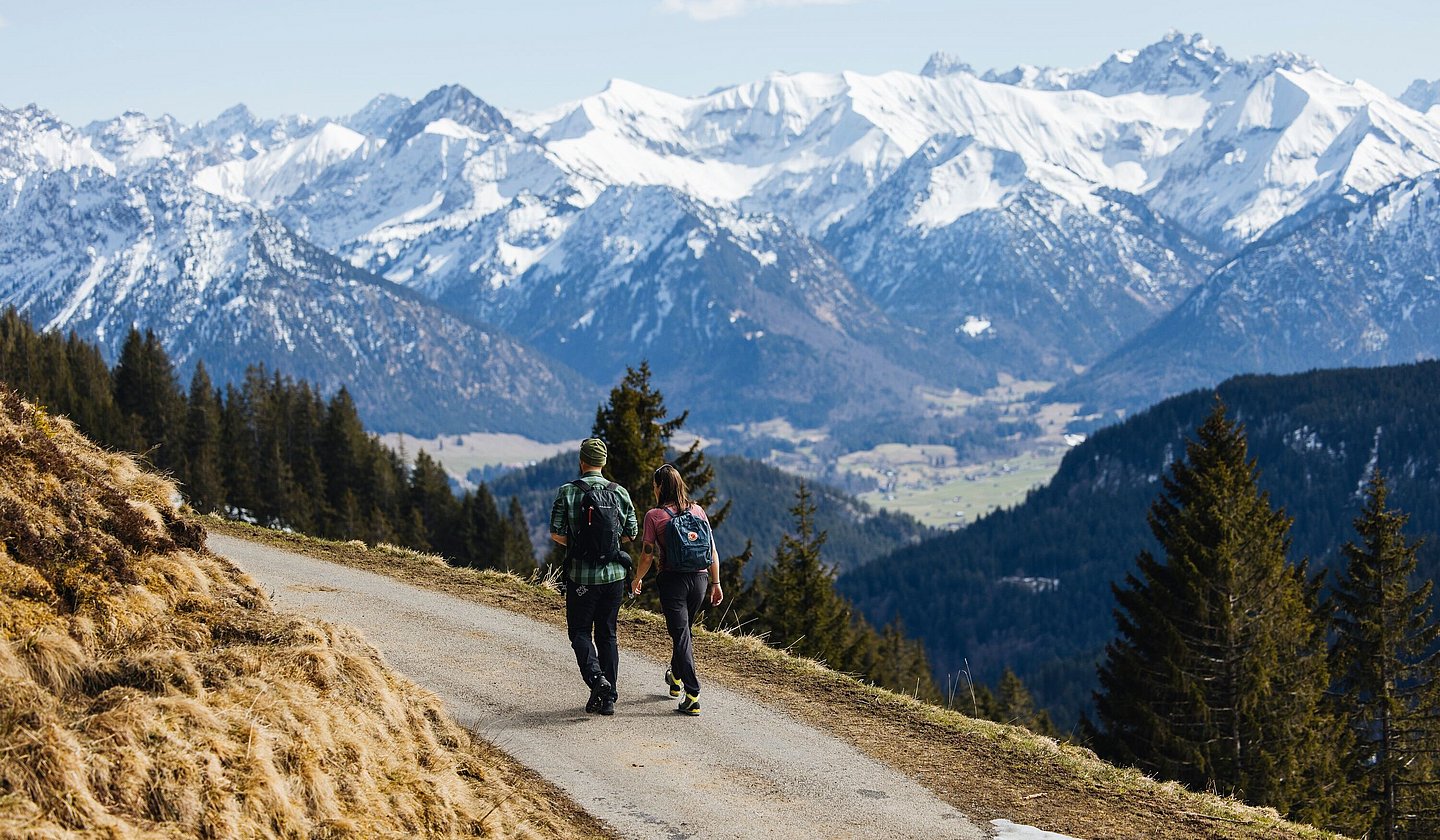 Wanderpaar am Bolsterlanger Horn mit Blick auf schneebedeckte Berge