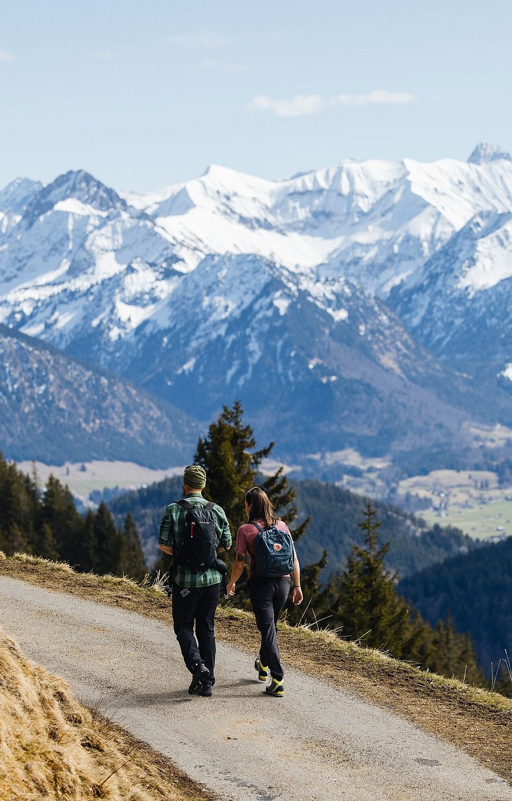 Wanderpaar am Bolsterlanger Horn mit Blick auf schneebedeckte Berge