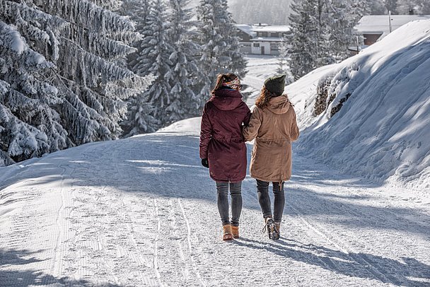 Zwei Frauen auf einem präparierten Winterwanderweg Zwei Frauen auf einem präparierten Winterwanderweg