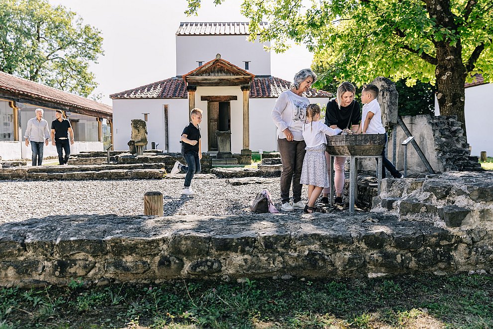 Eine Familie mit Kindern im Archäologischen Park Cambodunum