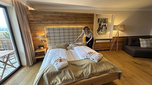 JobQuesterin Pia macht das Bett in einem Zimmer im Biohotel Eggensberger