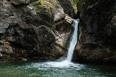 Zwei Frauen sitzen auf den Felsen vor dem Becken an den Buchenegger Wasserfällen
