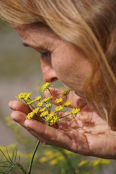 Eine Frau riecht an einer Blüte