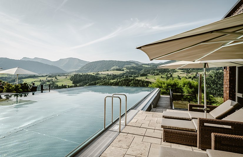 Außenpool mit Sonnenliegen und Bergblick