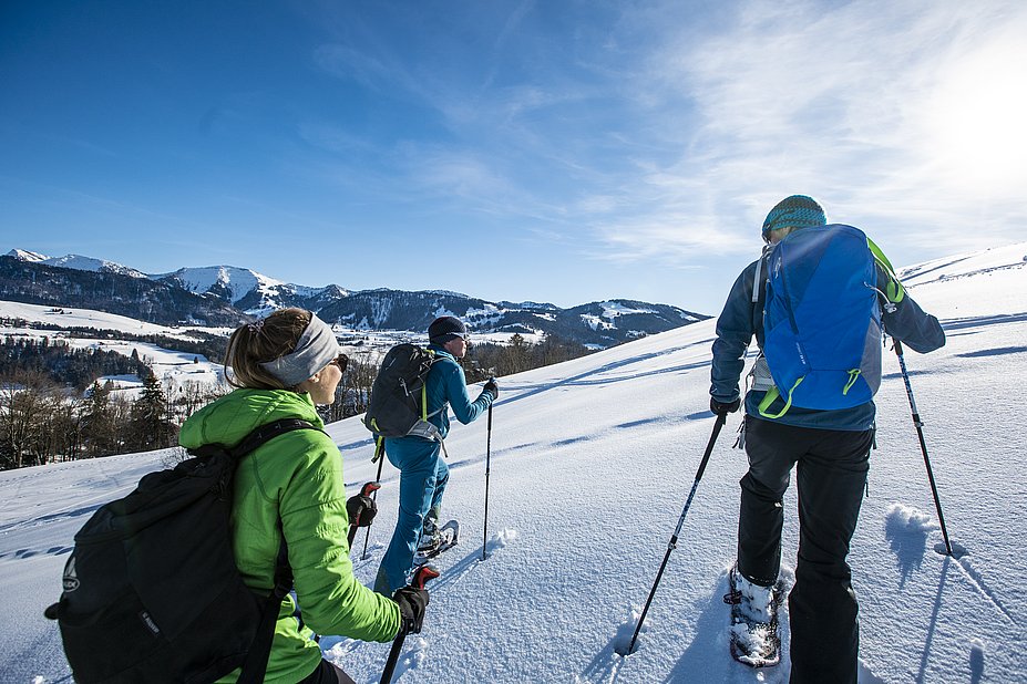 Drei Schneeschuhwanderer mit Blick auf die Nagelfluhkette