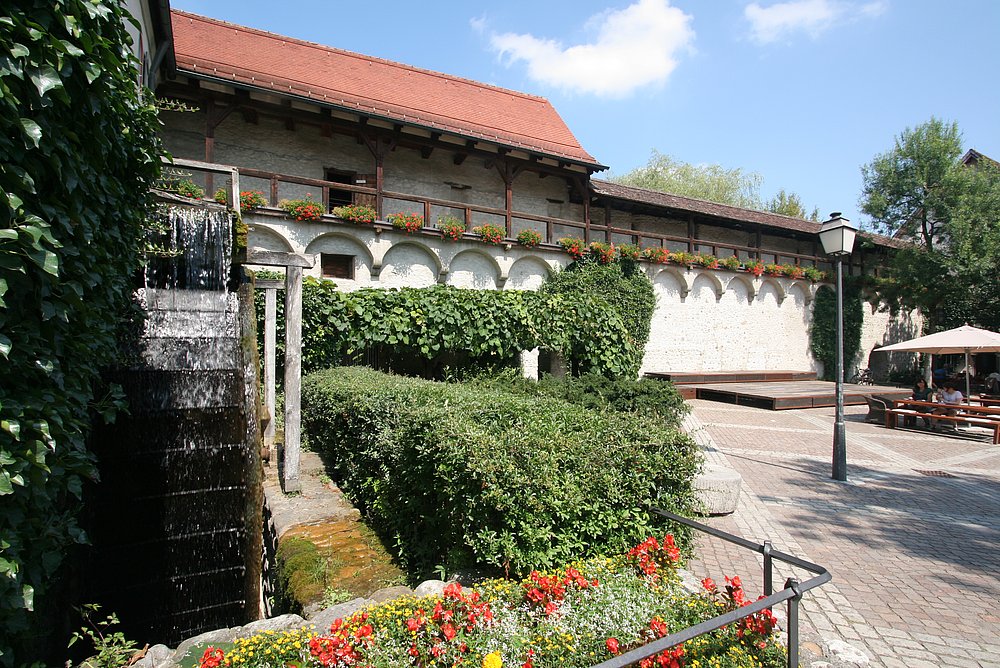 Ruhiger Innenhof in Wangen im Allgäu mit Begrünung und Wasserrad 