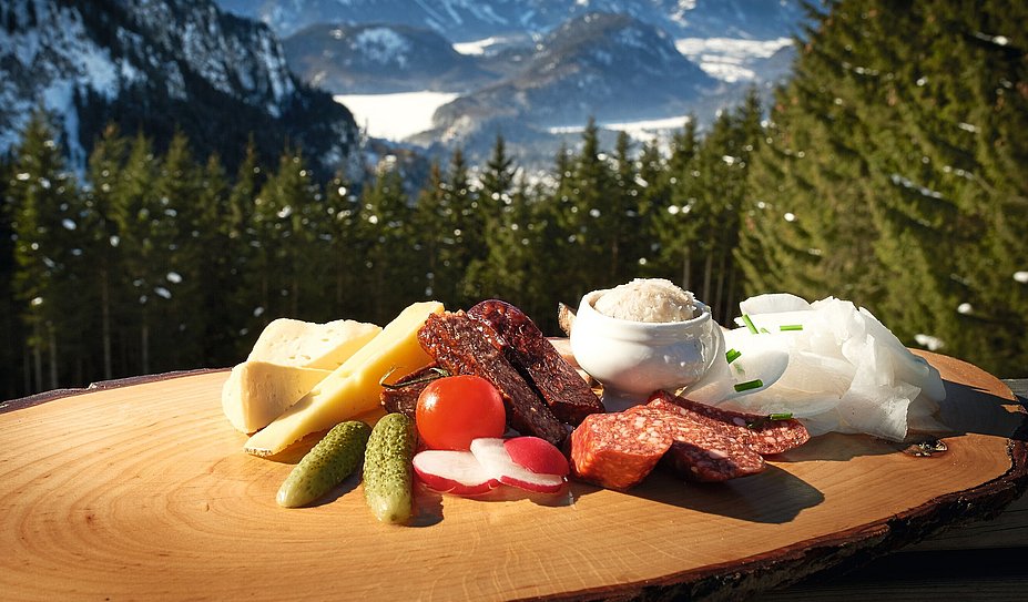 Brotzeit mit Käse und Wurst vor Bergpanorama
