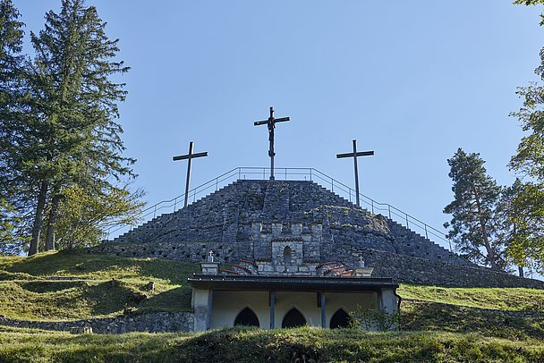 Drei Kreuze auf dem Kalvarienberg, umgeben von Bäumen