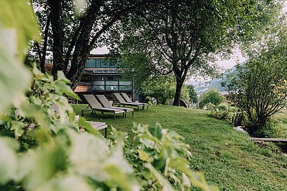 Liegen auf der Wiese vor dem Naturhotel Chesa Valisa umgeben von Bäumen
