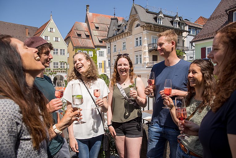 Lachende Gruppe mit Sektgläsern in der Hand in Isny