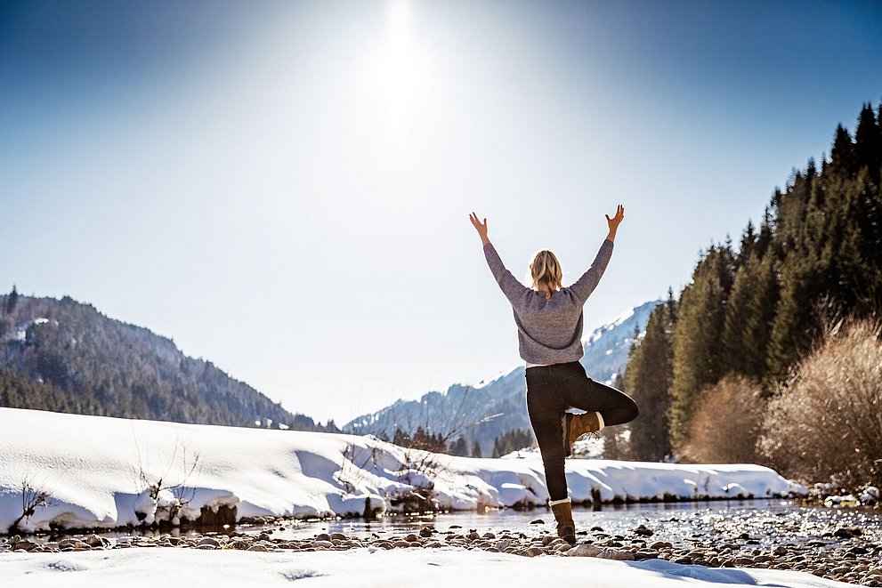 Frau macht Yoga im Winter im Allgäu