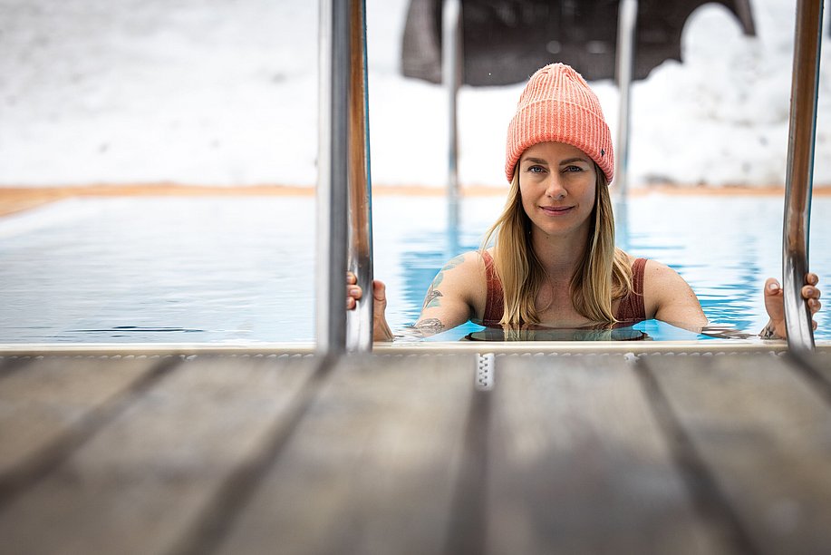 Frau mit Mütze steigt in einem Pool Frau mit Mütze steigt in einem Pool