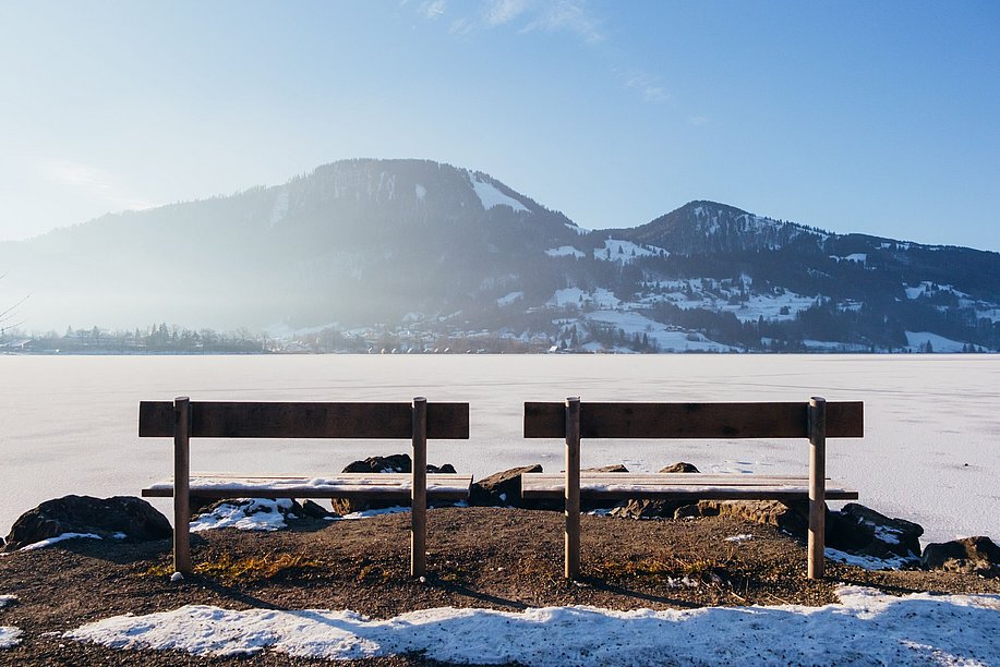 Zwei Bänke am Ufer des gefrorenen Großen Alpsees