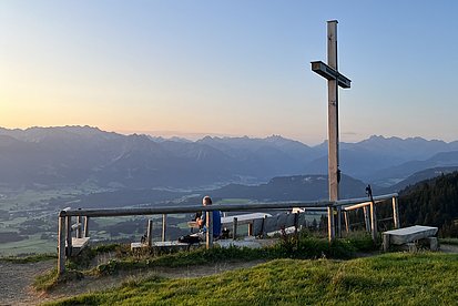 Das Gipfelkreuz auf dem Ofterschwanger Horn im Morgenlicht