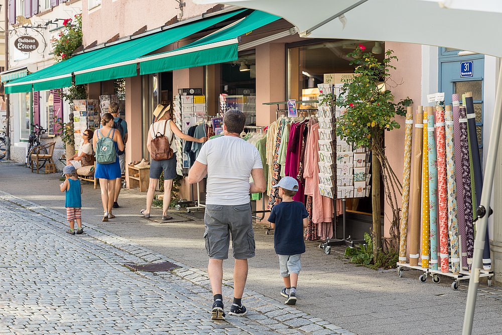 Menschen vor Geschäften in der Fußgängerzone in Isny
