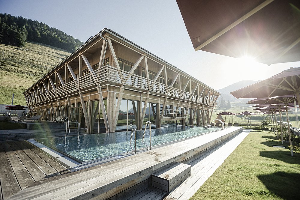 Außenansicht des Hotel Hubertus Mountain Refugio Allgäu mit Pool