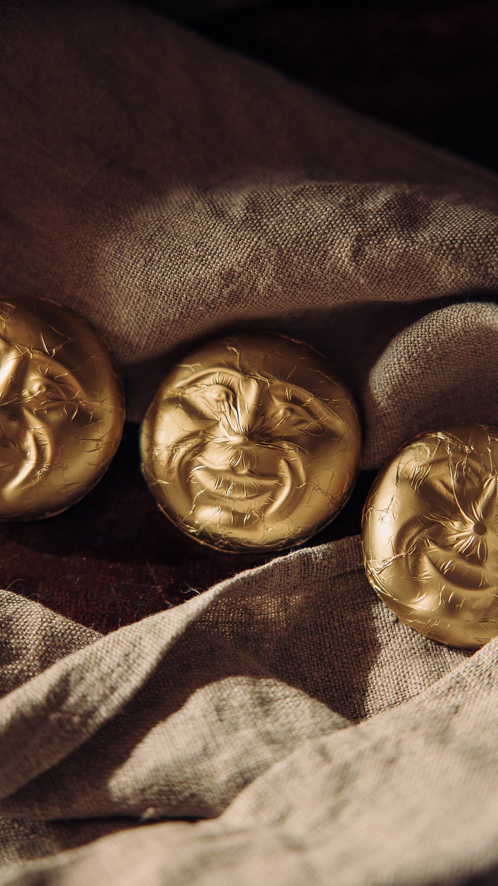 Drei Memminger Mau mit goldenem Mondgesicht auf einem grob gewebten Tuch