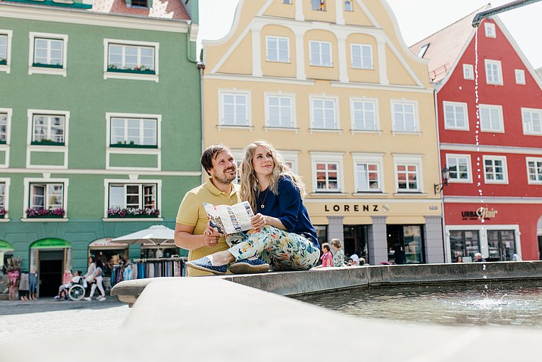 Memmingen Altstadt Junges Paar mit dem Stadtplan am Brunnen am Marktplatz