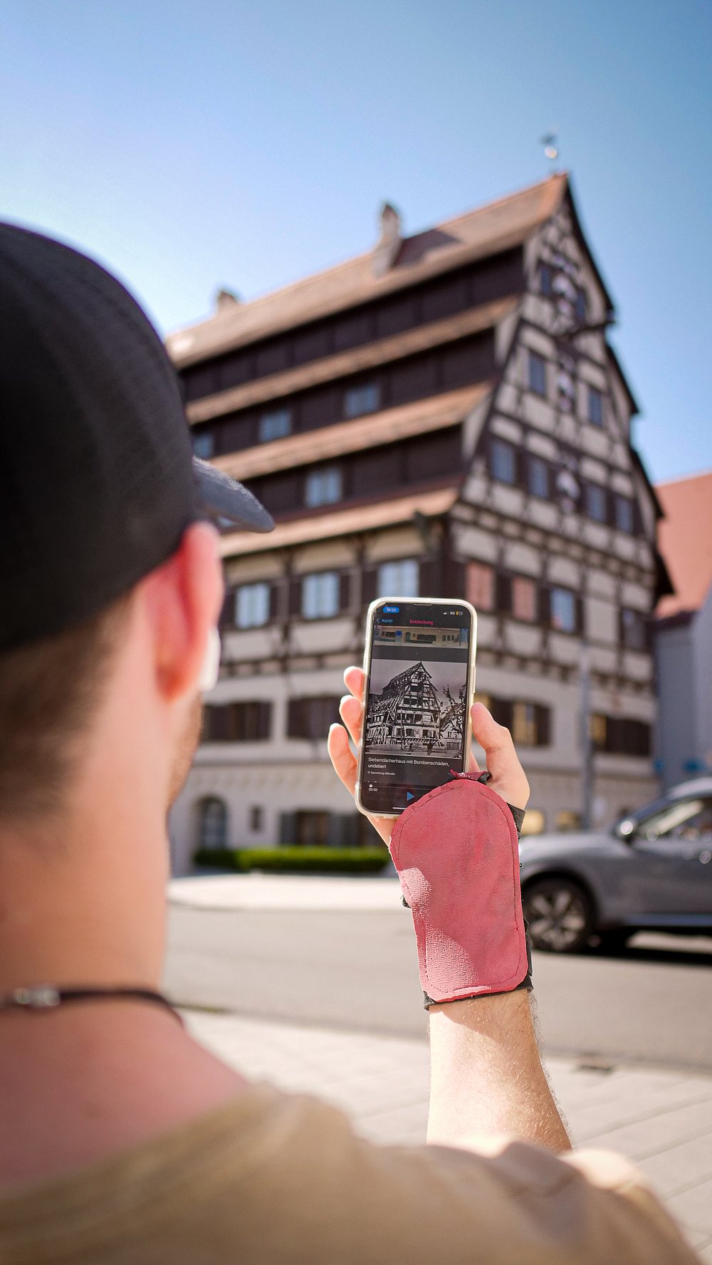 Moritz Brückner macht mit dem Handy ein Foto vom Dächerhaus in Memmingen