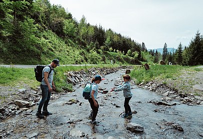 Familie überquert Bach am Abenteuerpfad Galetschbach Familie überquert Bach am Abenteuerpfad Galetschbach