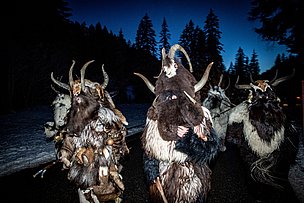 Als Klausen verkleidete Männer ziehen durch die Dämmerung