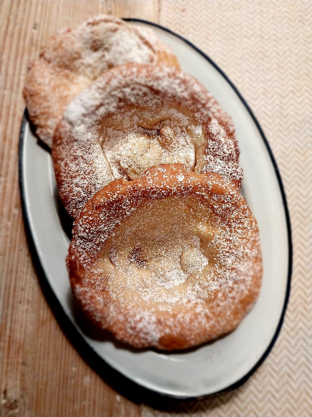 Drei frische Funkenküchle mit Puderzucker Drei frische Funkenküchle mit Puderzucker