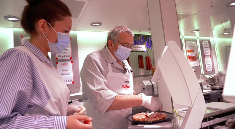 Filialleiter Reinhard Denzel mit Lauri beim Wurstplatten belegen